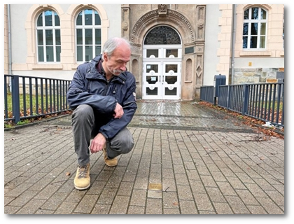 Michael Scharnowski, Schulleiter des Leibniz-Gymnasiums, vor dem Stolperstein, der an Wolfgang Maas erinnert